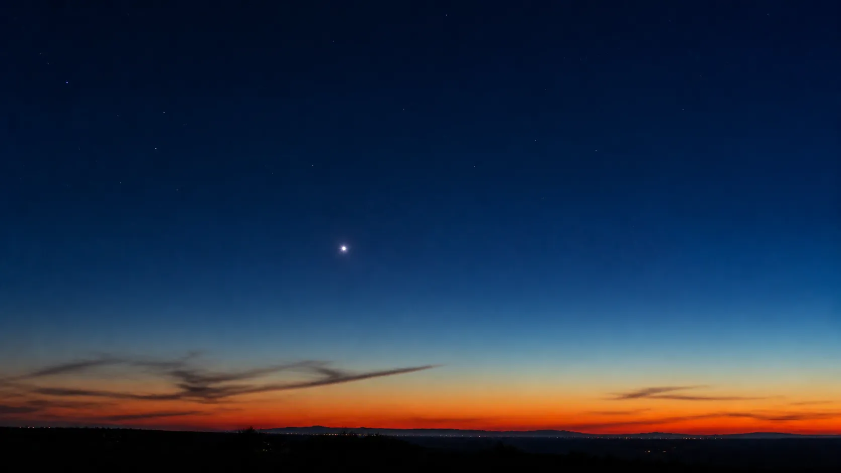 夕暮れの薄明の空に、ひときわ明るく白く輝く金星が低くかかっている