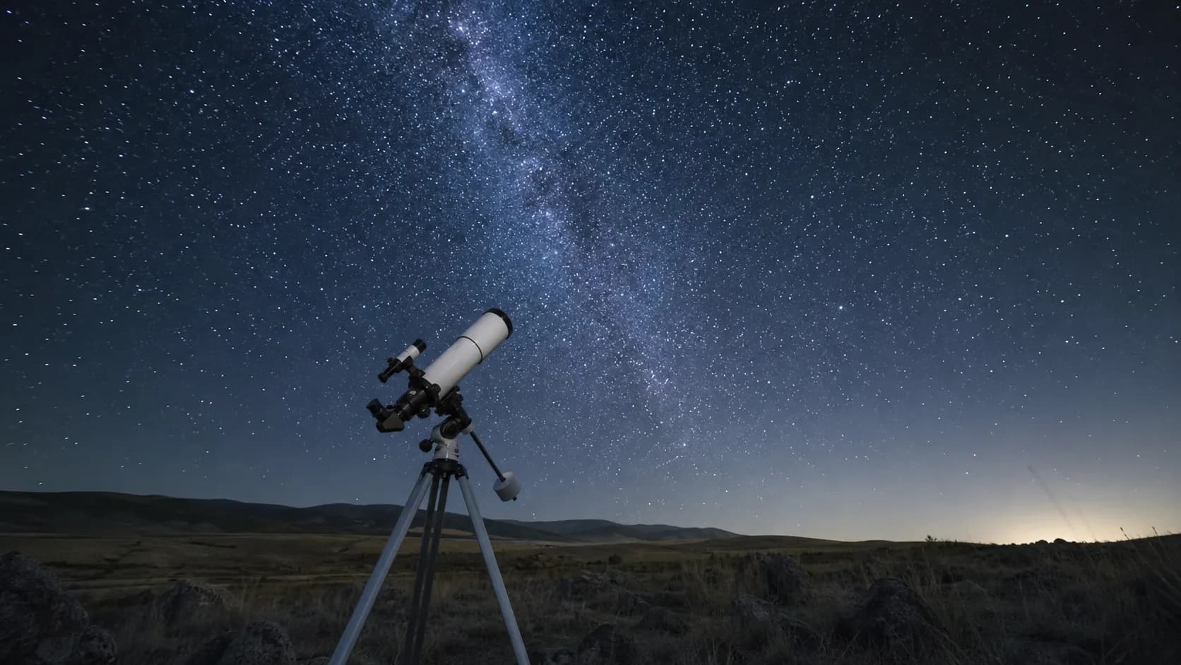 三脚に載った天体望遠鏡が、星のまたたく夜空へ向けられている