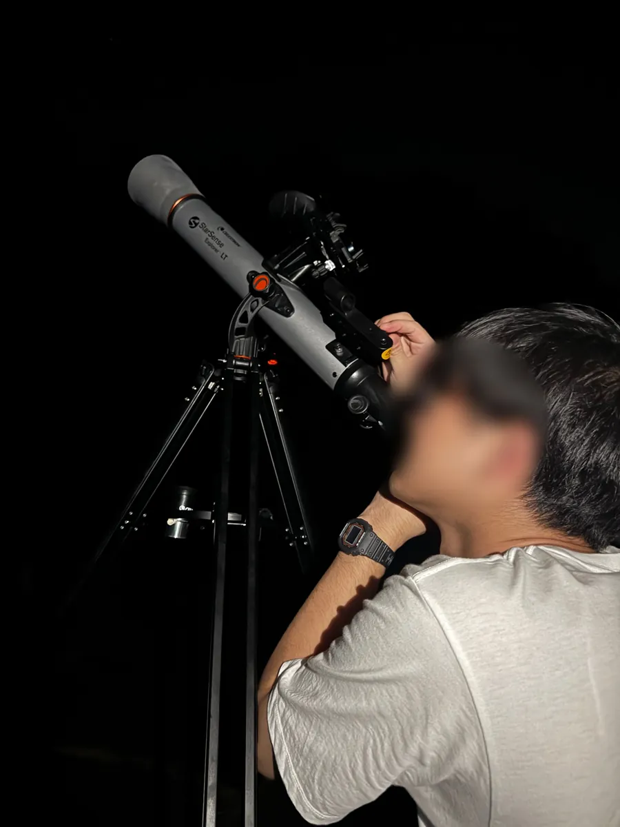 夜の森林公園で、StarSense Explorer LT 70AZの接眼レンズをのぞく編集部メンバー(顔はぼかしています)