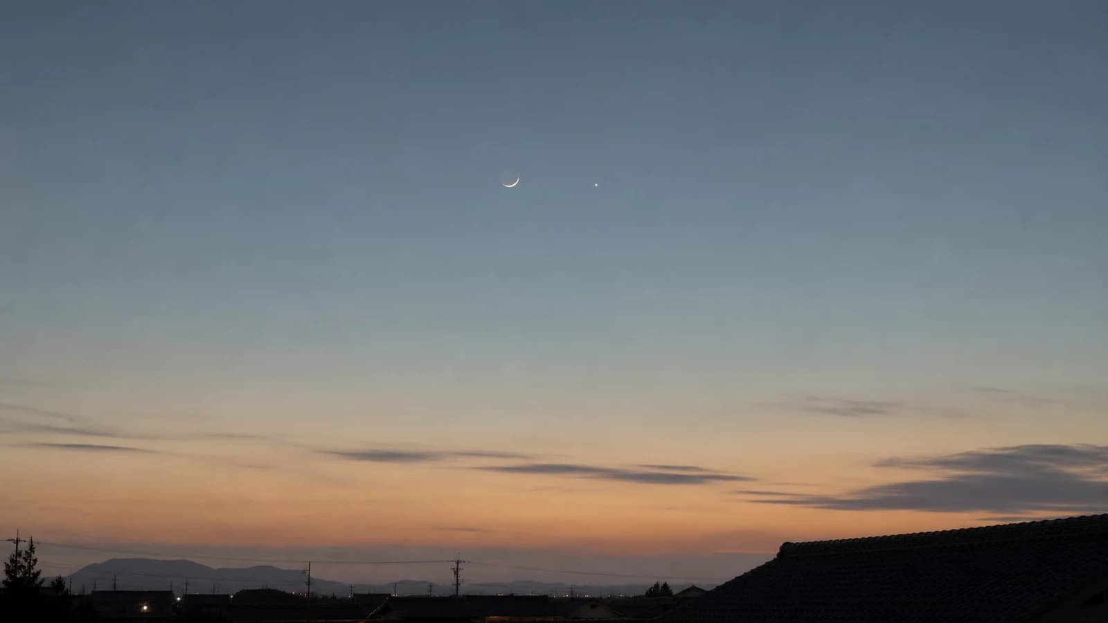 夕暮れの空に浮かぶ細い月と明るい星