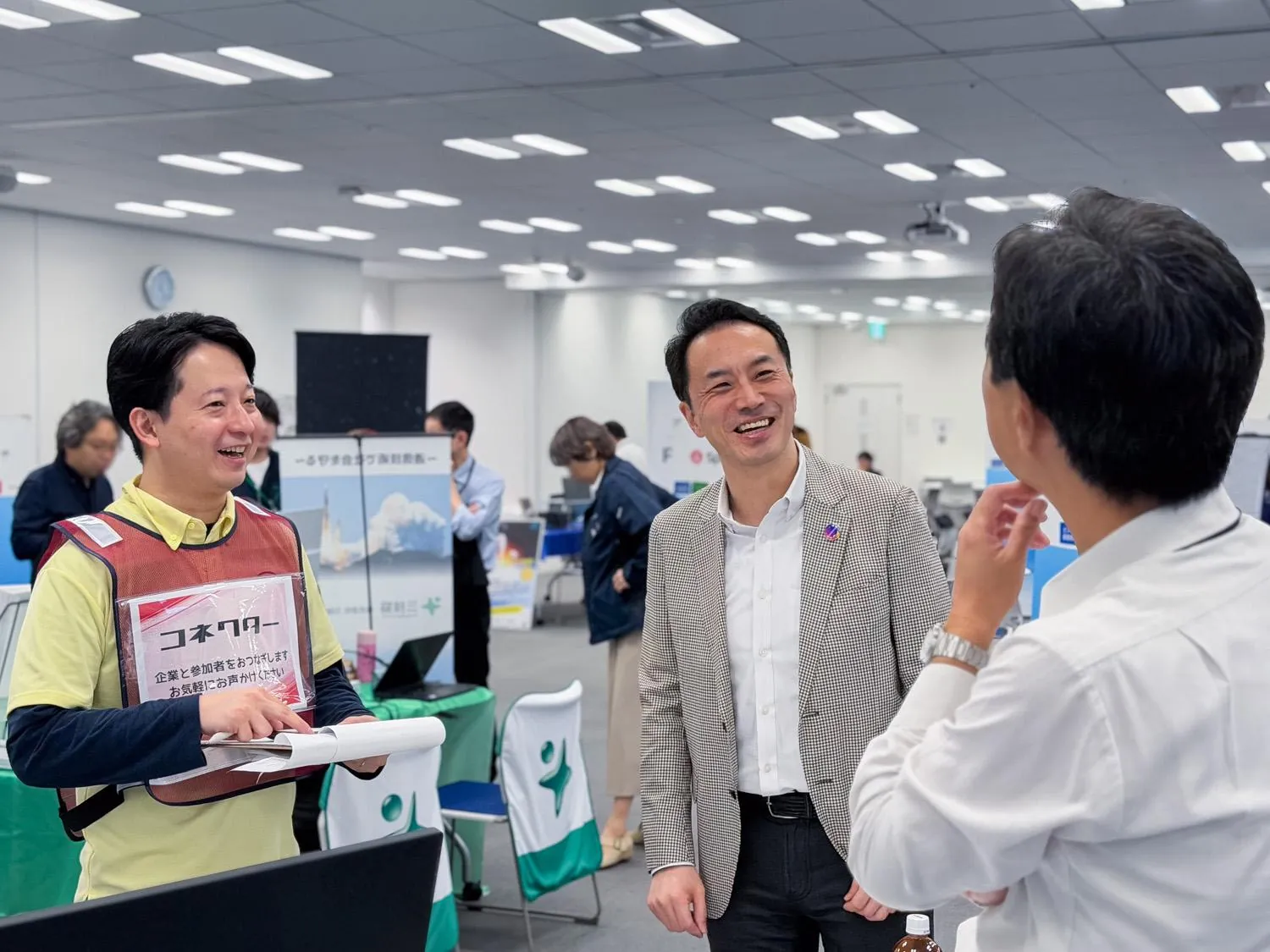 SPACETIDE Career Connect 2026の会場で、参加者に話を聞くスタッフと、笑顔で会話する参加者たち